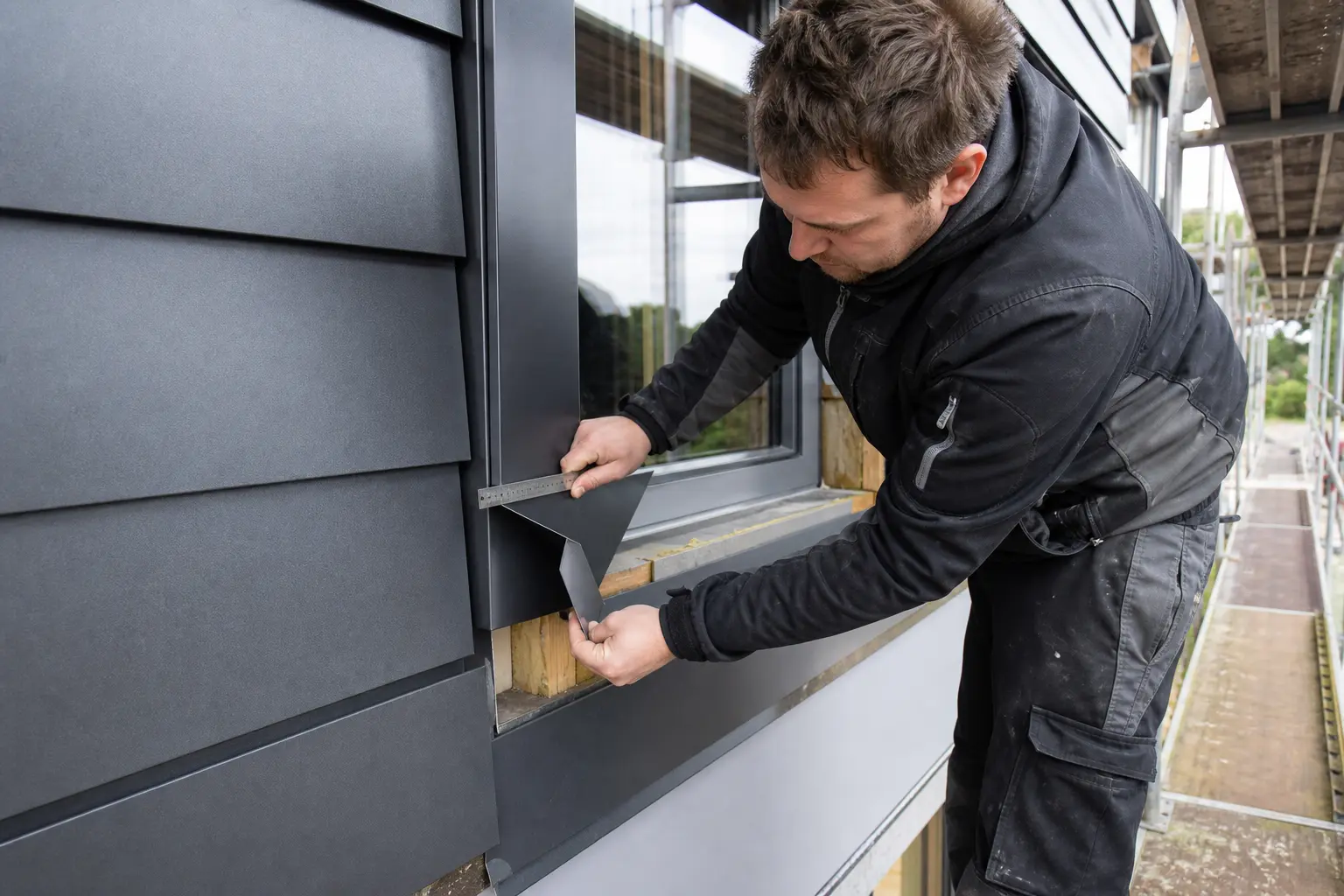 Fachmann passt ein gefaltetes Aluminiumdetail am Fenster an